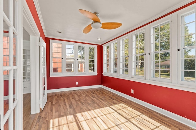 unfurnished sunroom featuring ceiling fan