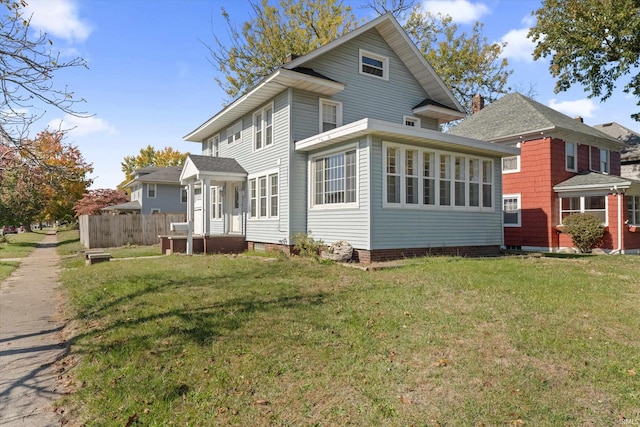 rear view of property with a sunroom and a lawn