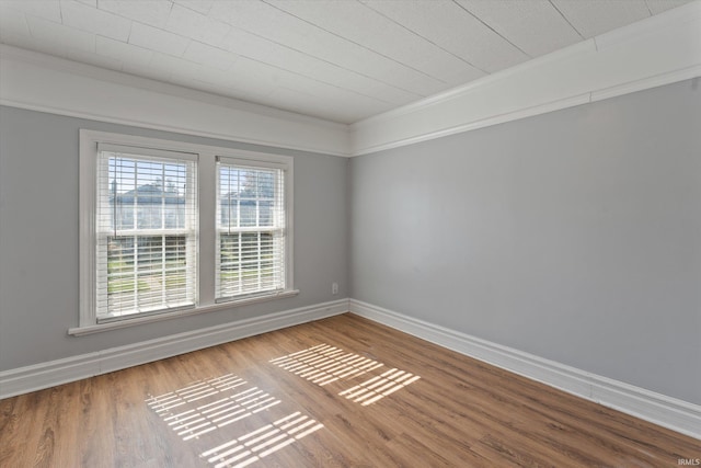 spare room with ornamental molding and hardwood / wood-style floors