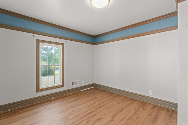 spare room featuring ornamental molding and hardwood / wood-style floors