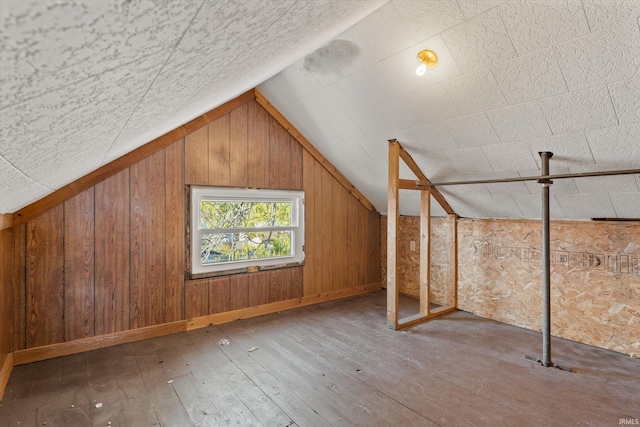 bonus room with lofted ceiling, hardwood / wood-style flooring, and wood walls