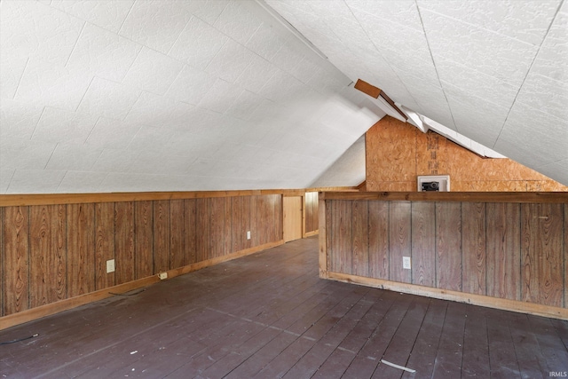 bonus room with wooden walls, vaulted ceiling, and dark hardwood / wood-style flooring