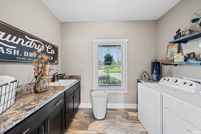 washroom with sink, independent washer and dryer, and cabinets