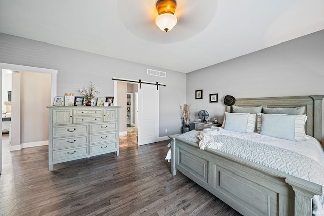 bedroom with dark wood-type flooring, a barn door, and ceiling fan