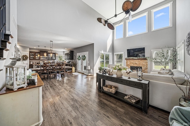 living room featuring a towering ceiling, wood-type flooring, and a fireplace