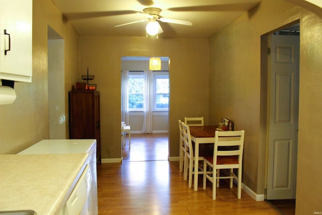 dining area with ceiling fan and light wood-type flooring