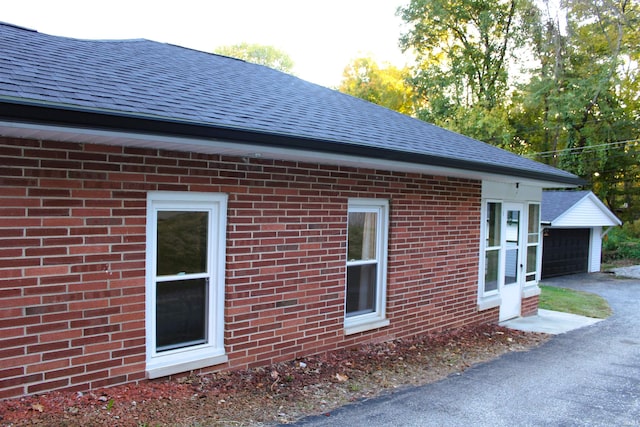 view of side of property with a garage and an outbuilding