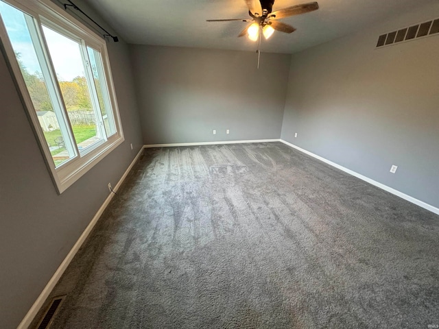 carpeted spare room featuring ceiling fan