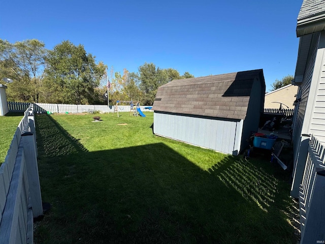 view of yard featuring a storage shed and a playground