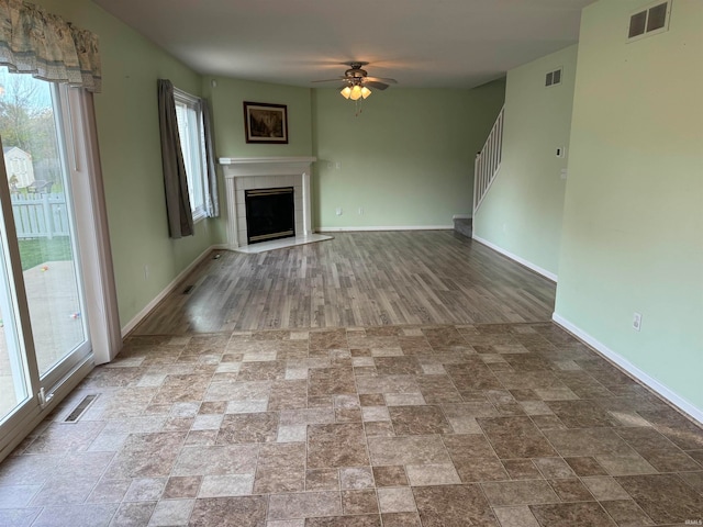 unfurnished living room with light hardwood / wood-style flooring, a fireplace, plenty of natural light, and ceiling fan