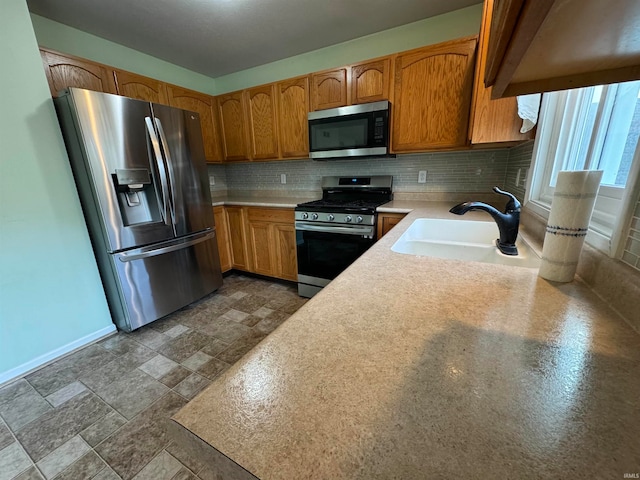 kitchen with appliances with stainless steel finishes, decorative backsplash, and sink