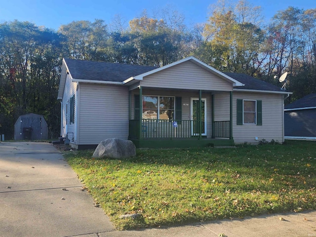 view of front of home featuring a front yard, a storage unit, and a porch