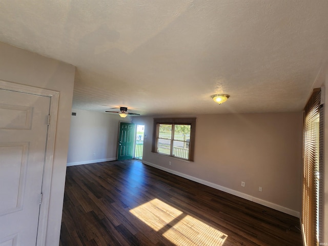 unfurnished room featuring ceiling fan, a textured ceiling, and dark hardwood / wood-style flooring