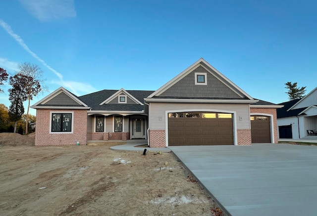 view of front of house with a garage, concrete driveway, and brick siding