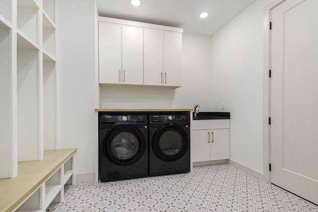 washroom featuring washing machine and dryer, cabinet space, baseboards, and recessed lighting