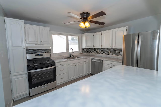 kitchen with ceiling fan, appliances with stainless steel finishes, backsplash, white cabinetry, and sink