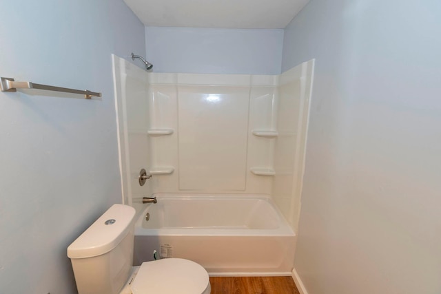 bathroom with toilet, hardwood / wood-style flooring, and shower / tub combination