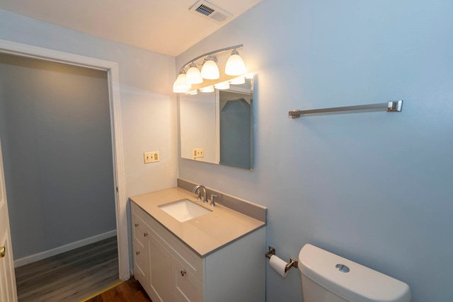 bathroom featuring vanity, hardwood / wood-style flooring, and toilet