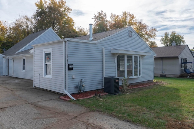 view of property exterior with central AC and a yard