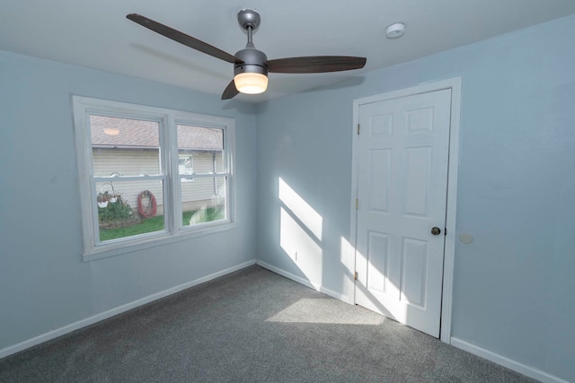 carpeted spare room featuring ceiling fan