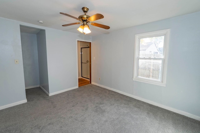 unfurnished room with ceiling fan and carpet