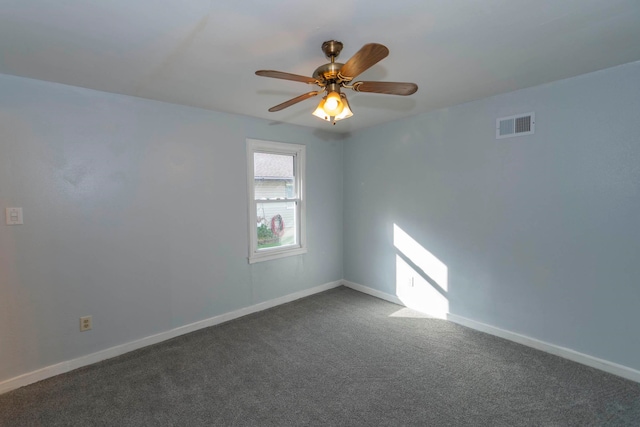 spare room with ceiling fan and dark colored carpet