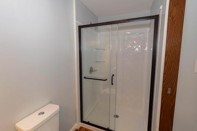 bathroom featuring toilet and an enclosed shower