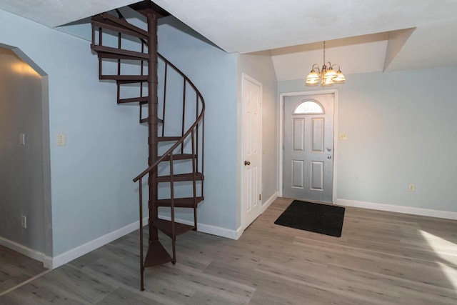 foyer with a chandelier, vaulted ceiling, and hardwood / wood-style flooring