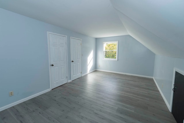 bonus room with wood-type flooring and vaulted ceiling