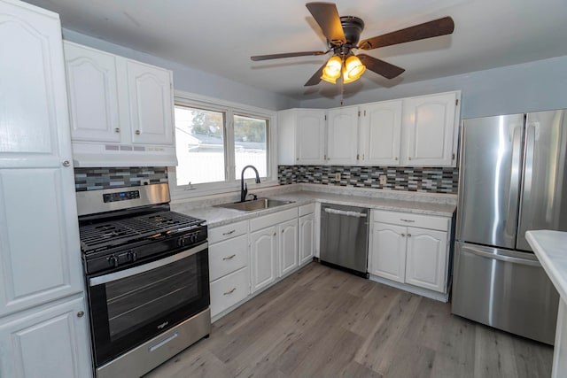 kitchen featuring extractor fan, sink, white cabinets, appliances with stainless steel finishes, and tasteful backsplash