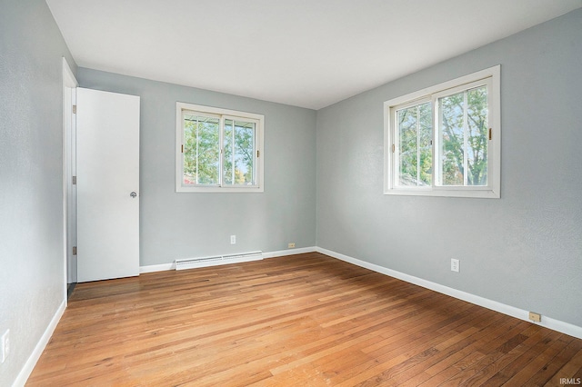 unfurnished room featuring a baseboard radiator and light wood-type flooring