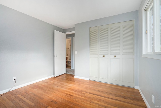 unfurnished bedroom featuring a closet and light hardwood / wood-style floors