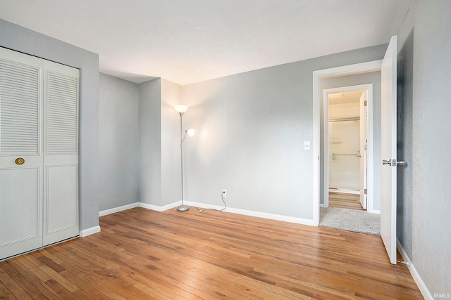 unfurnished bedroom with a closet and light hardwood / wood-style flooring