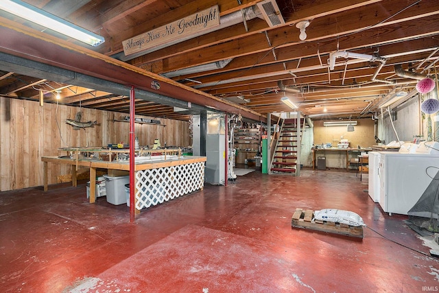 basement featuring independent washer and dryer and wooden walls