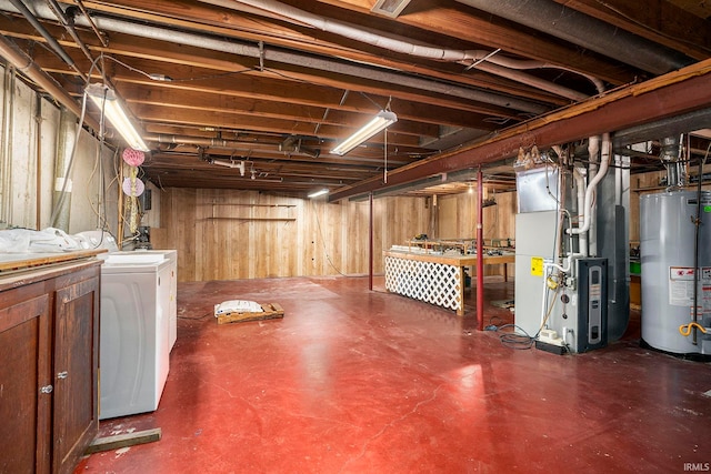 basement featuring water heater, washing machine and dryer, heating unit, and wooden walls