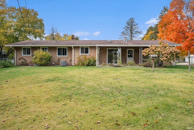 back of house with central AC and a lawn