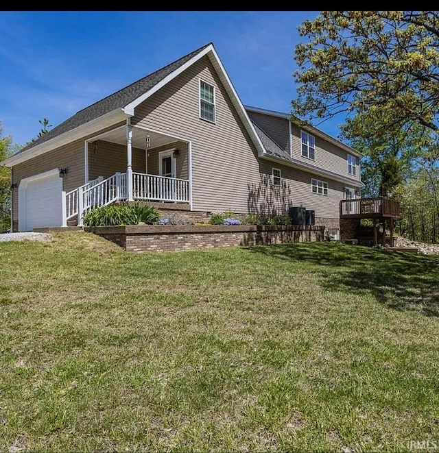 exterior space with a front lawn, a deck, covered porch, and a garage