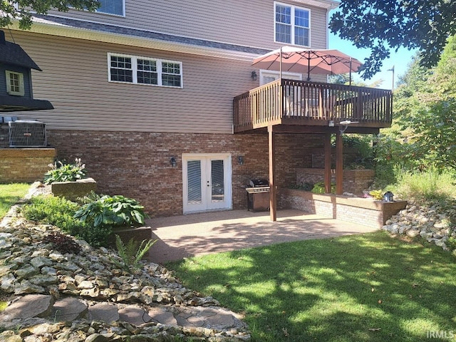 rear view of house with a patio area, central AC, french doors, a wooden deck, and a lawn