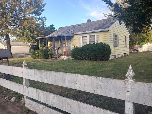 bungalow with a front yard and a porch