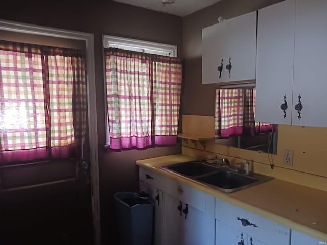 kitchen featuring white cabinetry and sink