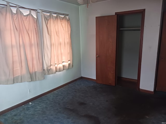 unfurnished bedroom featuring a closet and dark colored carpet