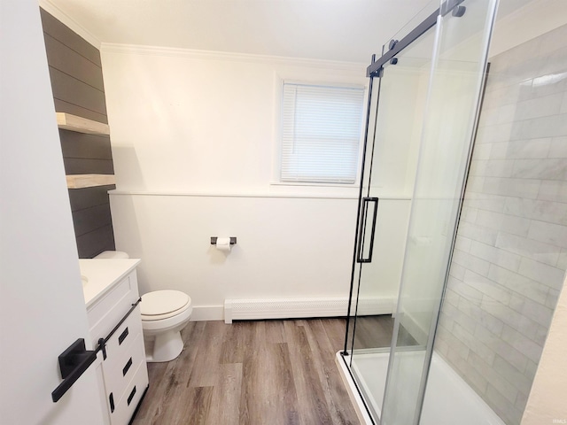 bathroom with wood-type flooring, toilet, crown molding, vanity, and an enclosed shower