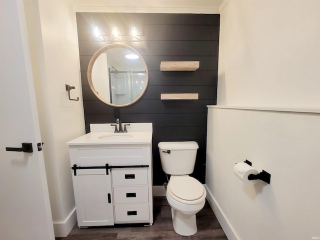 bathroom with vanity, toilet, wood-type flooring, and ornamental molding