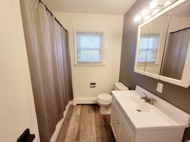 bathroom with toilet, baseboard heating, hardwood / wood-style floors, vanity, and walk in shower