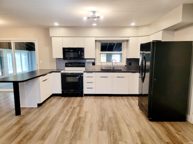 kitchen with kitchen peninsula, black appliances, white cabinets, light hardwood / wood-style floors, and tasteful backsplash