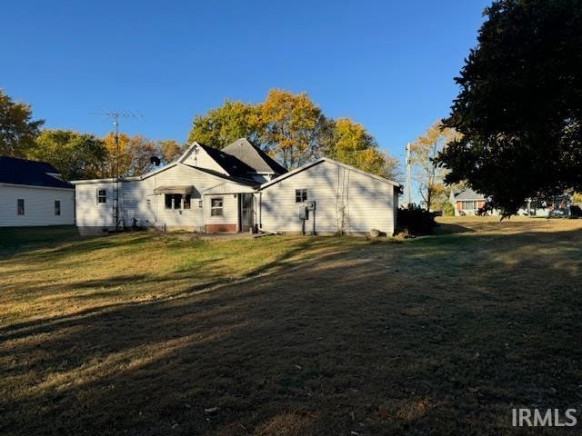 rear view of property with a yard