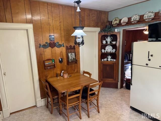 dining space featuring wood walls