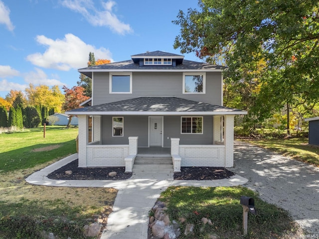 view of front facade featuring a front yard and covered porch