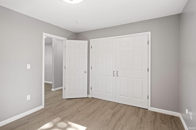 unfurnished bedroom featuring light hardwood / wood-style flooring and a closet