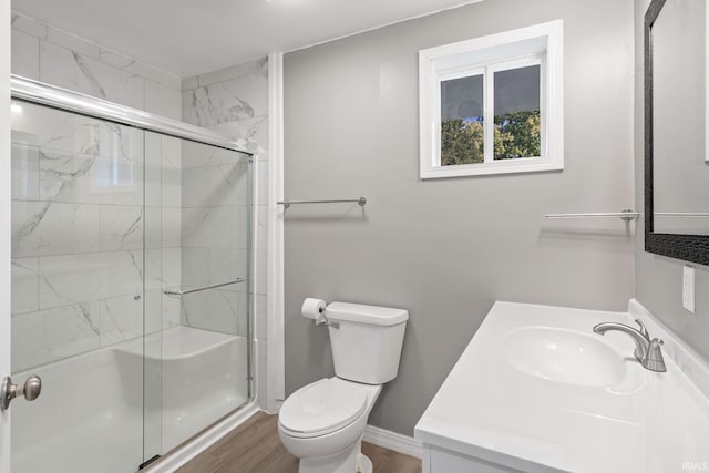 bathroom with toilet, a shower with shower door, vanity, and wood-type flooring